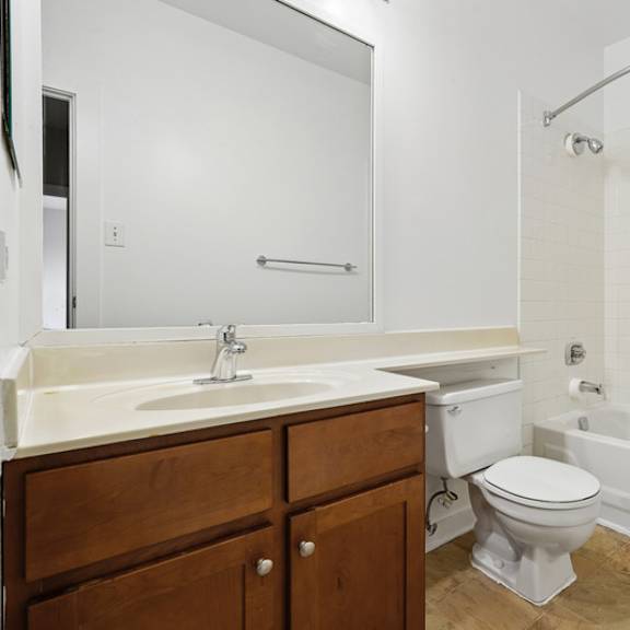 a white bathroom with a toilet, sink, and bathtub.