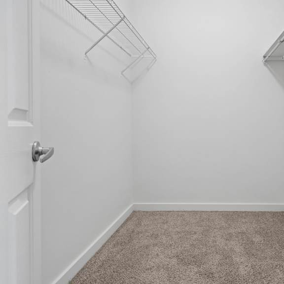 a white room with a carpeted floor and a white door.