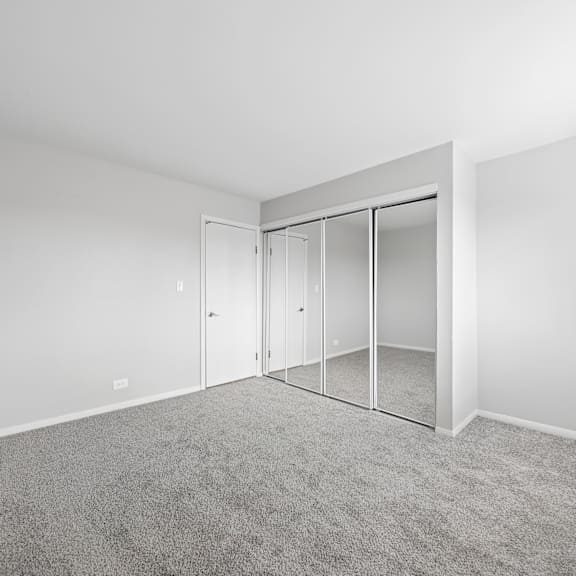 a room with a grey carpet and a white door.
