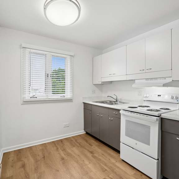a white kitchen with a stove, oven, and refrigerator.