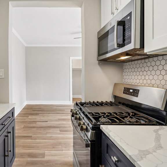 a kitchen with a black stove top oven and white cabinets.