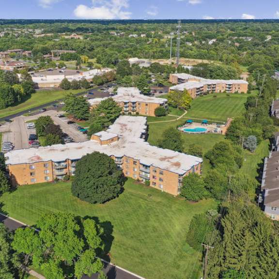 a bird's eye view of a residential area with apartment buildings and a pool.