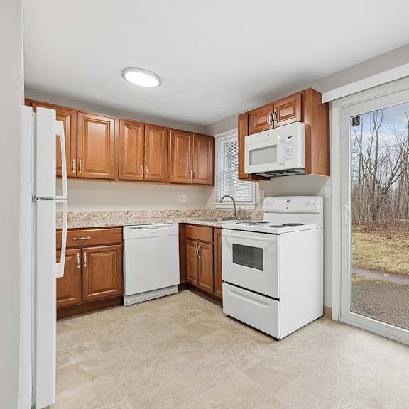 a kitchen with white appliances and wooden cabinets.