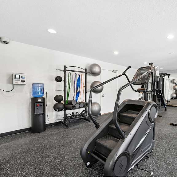 a gym with a treadmill, exercise bike, and weights.