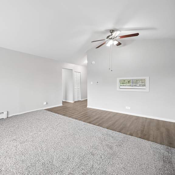 a room with a ceiling fan and a carpeted floor.