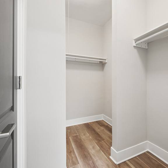 a white bathroom with a towel bar and a toilet paper holder.