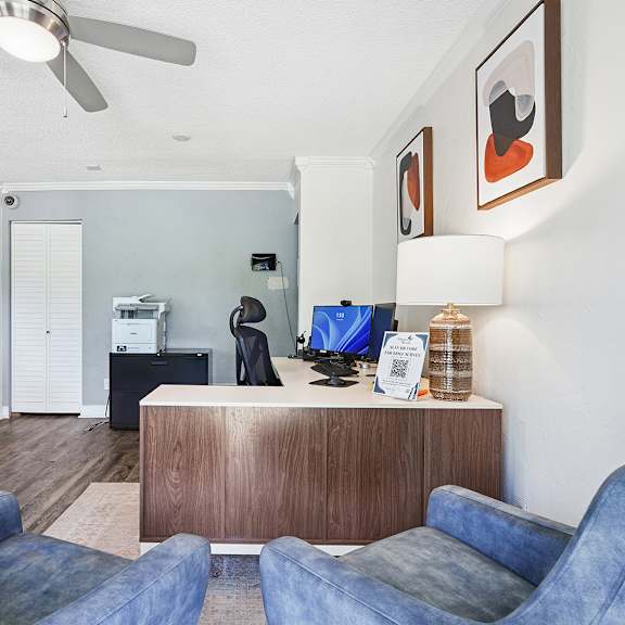 a living room with a blue couch and a wooden cabinet.