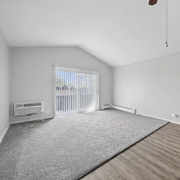a room with a grey carpet and wooden flooring.
