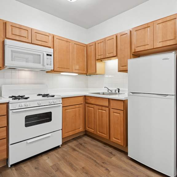 a kitchen with wooden cabinets and white appliances.