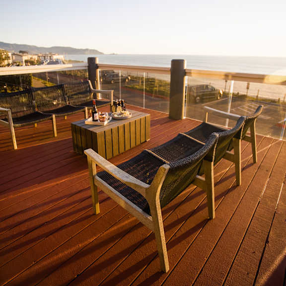 a deck with a table and chairs overlooking the ocean
