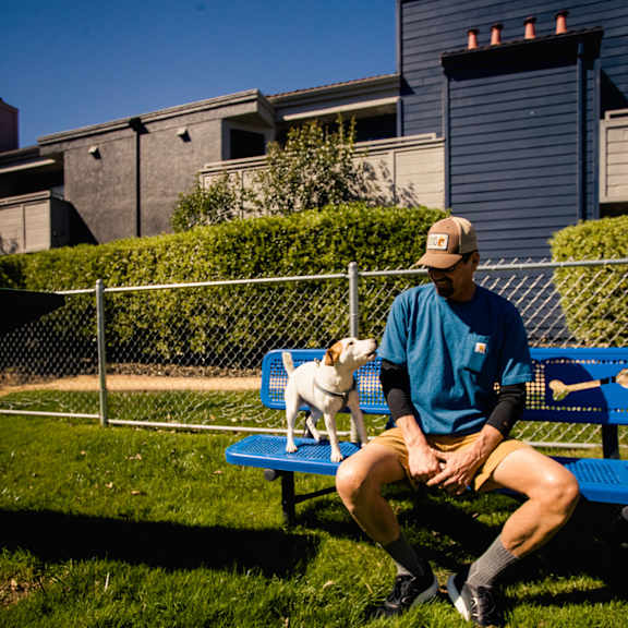 a man sitting on a bench with his dog