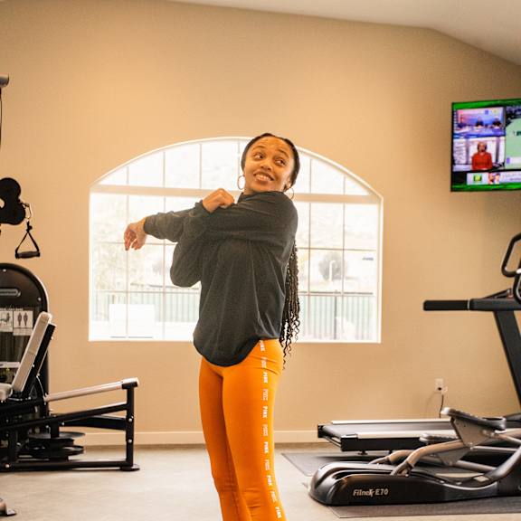a young woman standing on a yoga mat in a fitness room