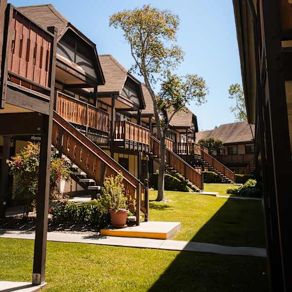 a row of wooden houses with stairs in a yard at oak park apartments, california