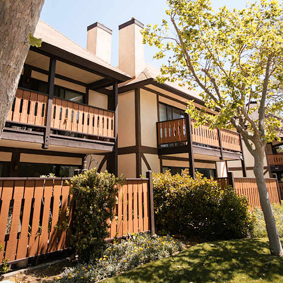 a view of the exterior of a building with benches at oak park apartments, solvang, ca