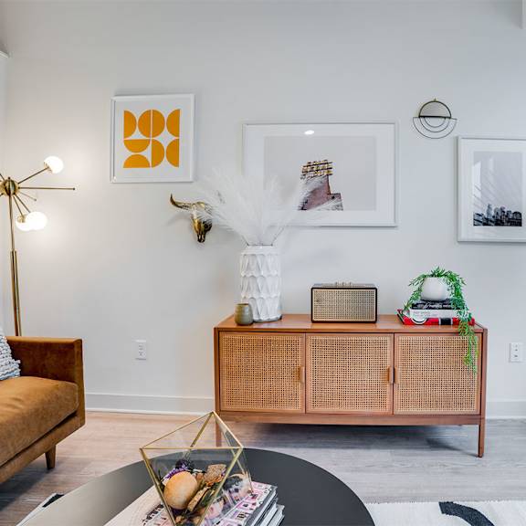 a living room with a brown sofa, a white coffee table, and a green plant. at sora apartments, minneapolis