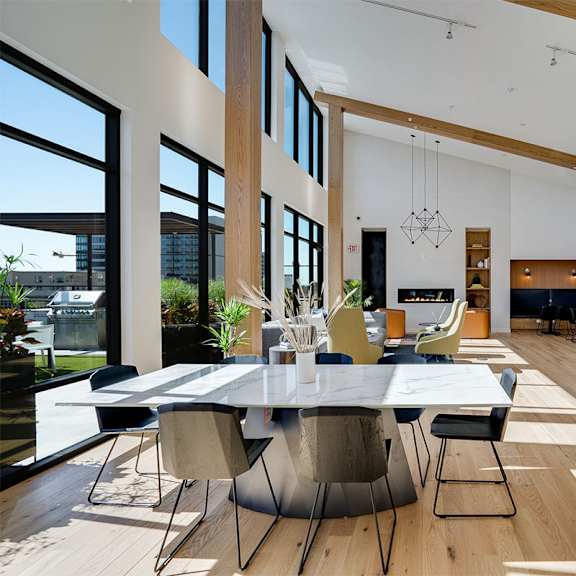lounge room with a large table and chairs at sora apartments, minnesota, 55415