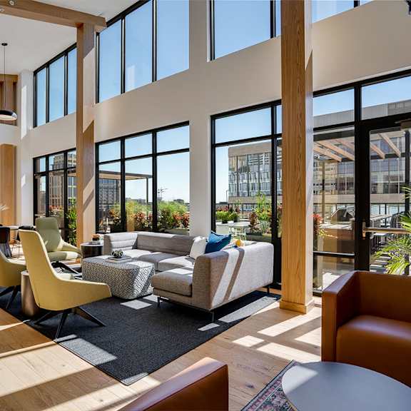 a modern lounge with a large window and a view of the city at sora apartments, minneapolis, minnesota