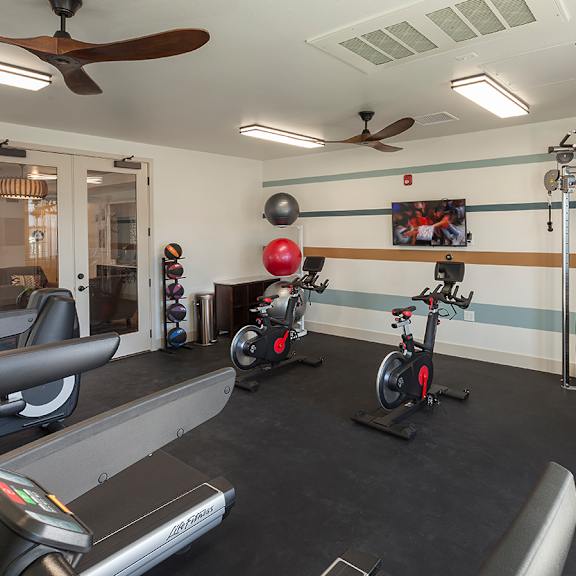 a home gym with exercise equipment and a tv at arrive los carneros apartments, california