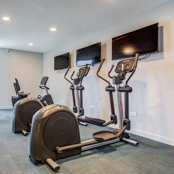 a gym with cardio machines and flat screen televisionsat the township at st. charles, st. charles