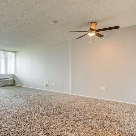 an empty living room with a ceiling fan at the township at st. charles, illinois