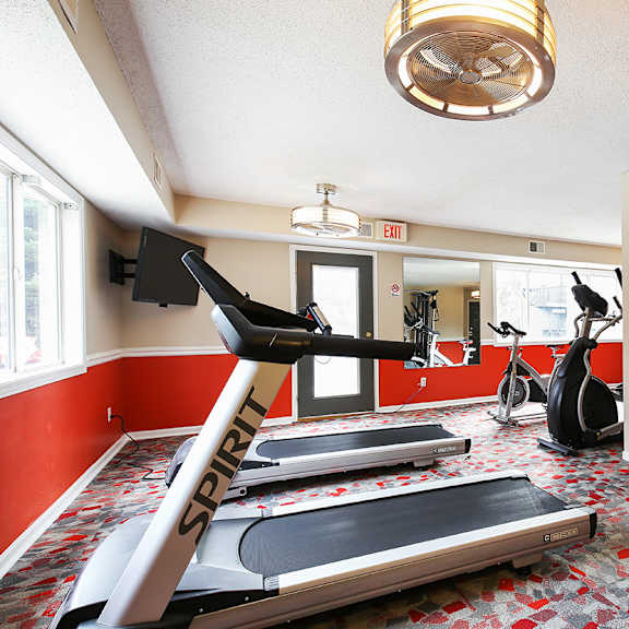 a gym with treadmills and other exercise equipment at the enclave at university crossings