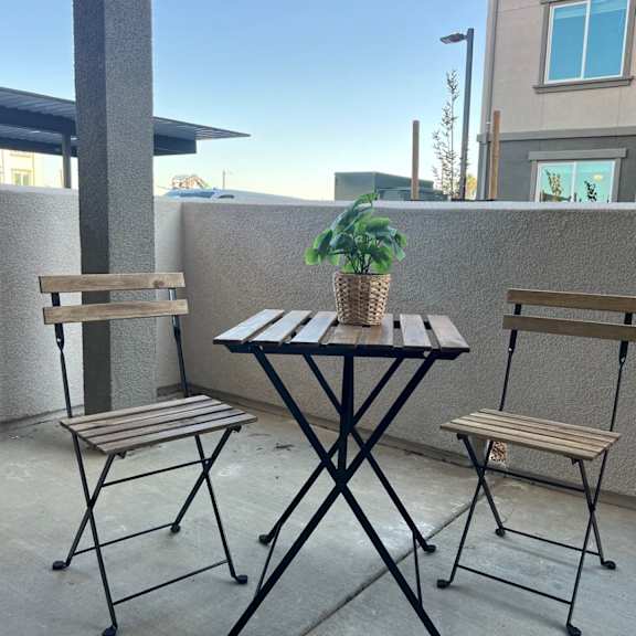 a table with two chairs and a plant on a balcony