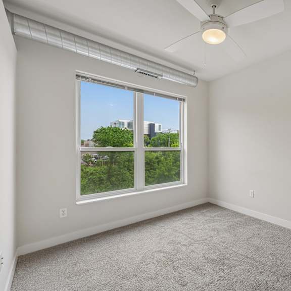 a room with a window and a ceiling fan.