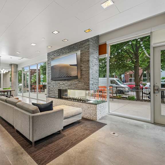 a modern living room with a large couch and a stone fireplace.