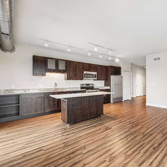 a kitchen with wooden floors and a white wall.