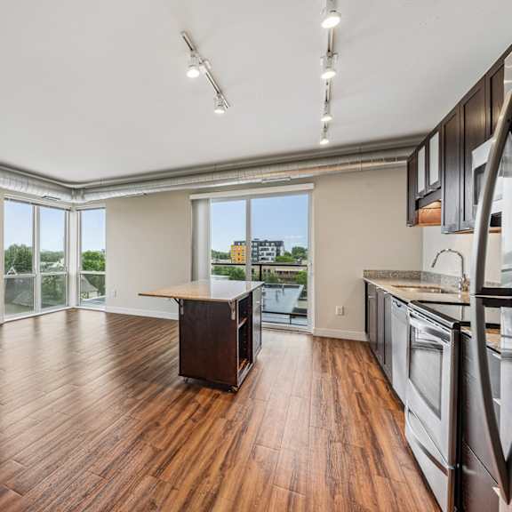 a kitchen with a wooden floor and stainless steel appliances.