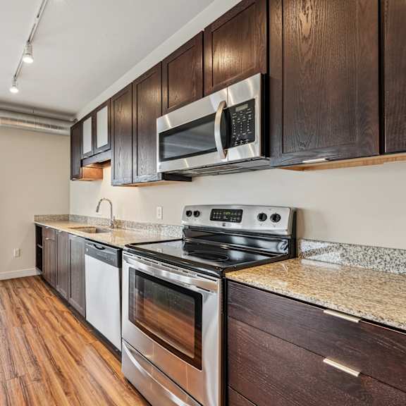 a kitchen with dark wood cabinets and stainless steel appliances.