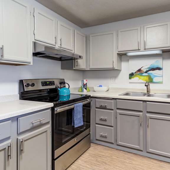 a kitchen with white cabinets and a black stove top oven