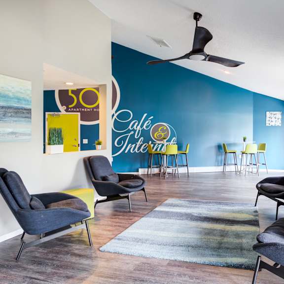 a lounge area with chairs and a rug