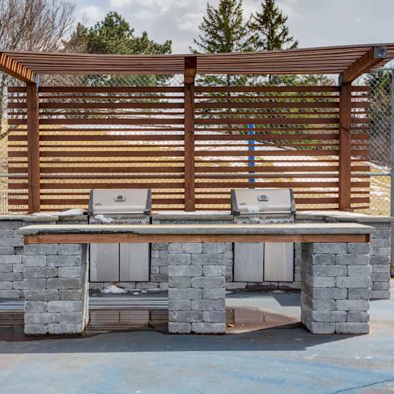 a stone barbecue grill with a wooden awning