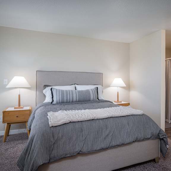 a bedroom with a bed and two lamps and a closet at sundial apartments, wilsonville, or