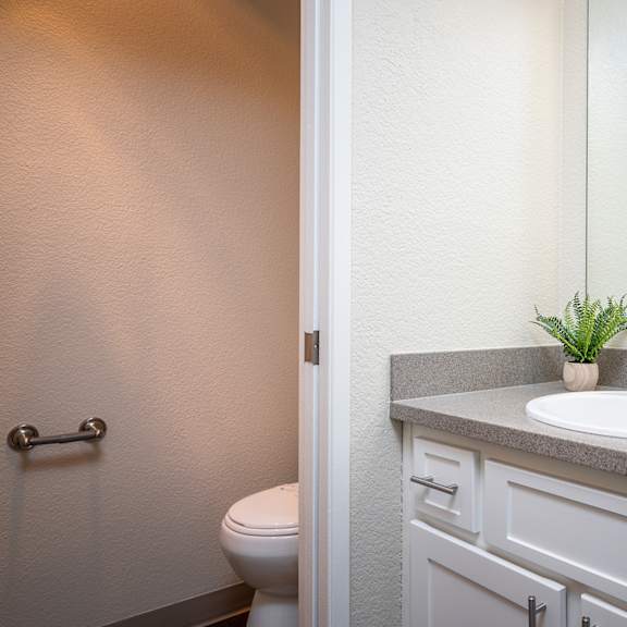 a bathroom with a sink and a toilet and a mirror at sundial apartments, wilsonville
