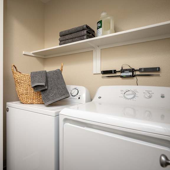 a laundry room with a washer and dryer and a door to the bathroom at sundial apartments, wilsonville, or 97070