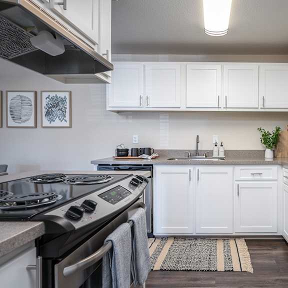 a kitchen with white cabinets and stainless steel appliances at sundial apartments, oregon, 97070