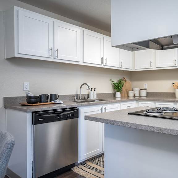 a kitchen with white cabinets and stainless steel appliances and a counter top at sundial apartments, oregon