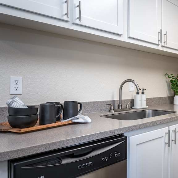 a kitchen with white cabinets and a sink at sundial apartments, wilsonville, or 97070
