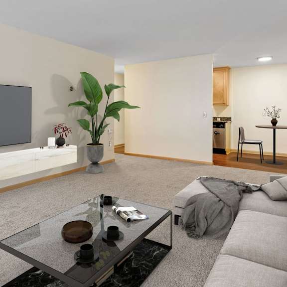 a modern living room with a grey sofa, a glass coffee table, and a flat-screen tv mounted on the wall.
