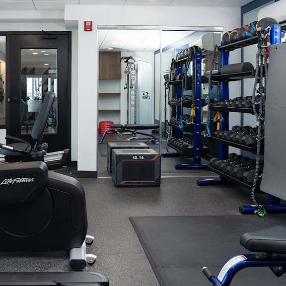a gym with a treadmill, exercise bike, and weights.