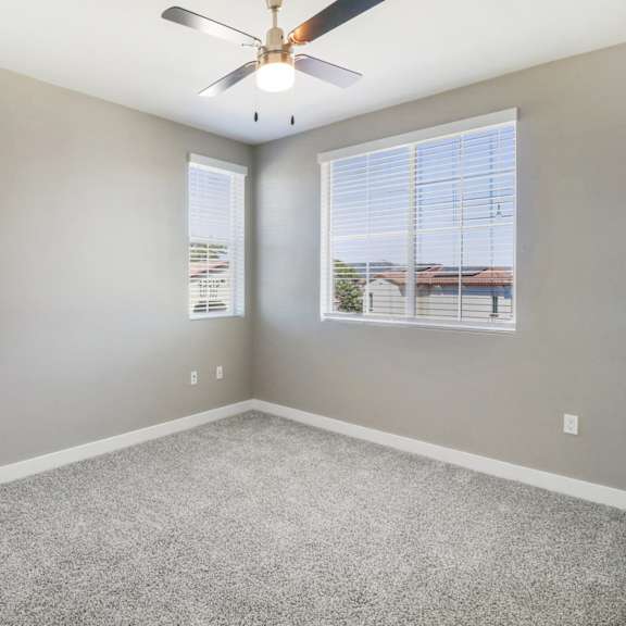 bedroom with ceiling fan and windows at arrive temecula