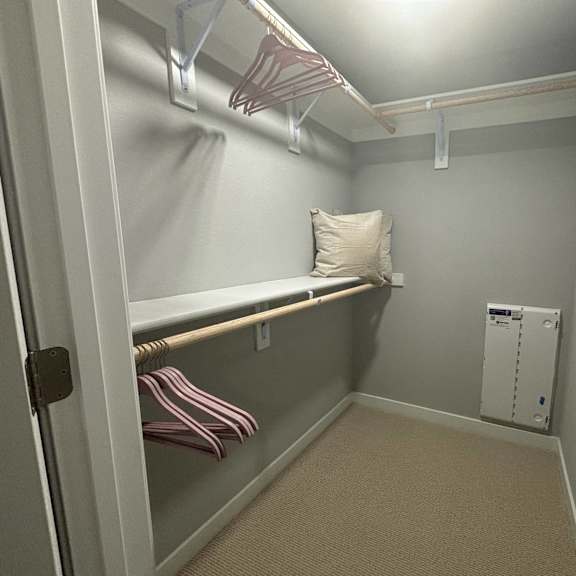 a walk in closet with a pillow on a shelf