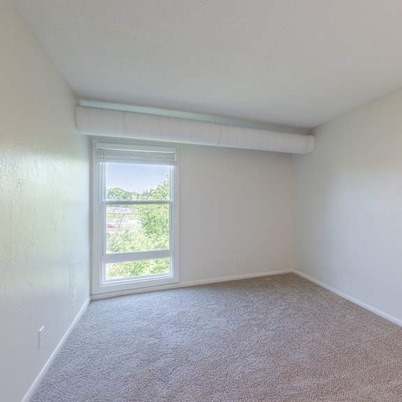 a room with a carpeted floor and a window.