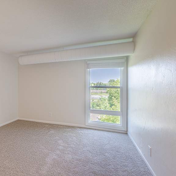 a room with a window and carpeted floor.