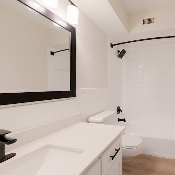 a white bathroom with a toilet, sink, and bathtub.