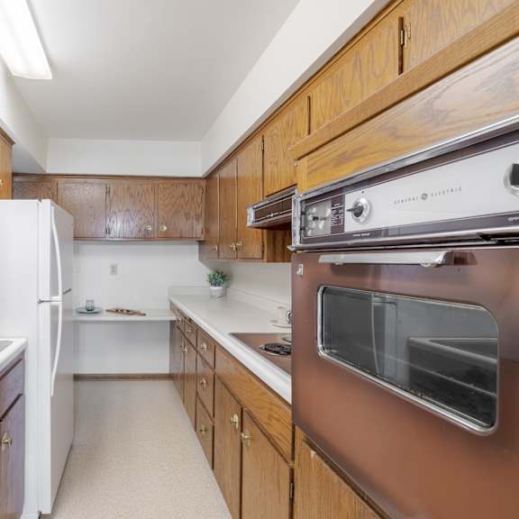 a kitchen with brown cabinets and white appliances.