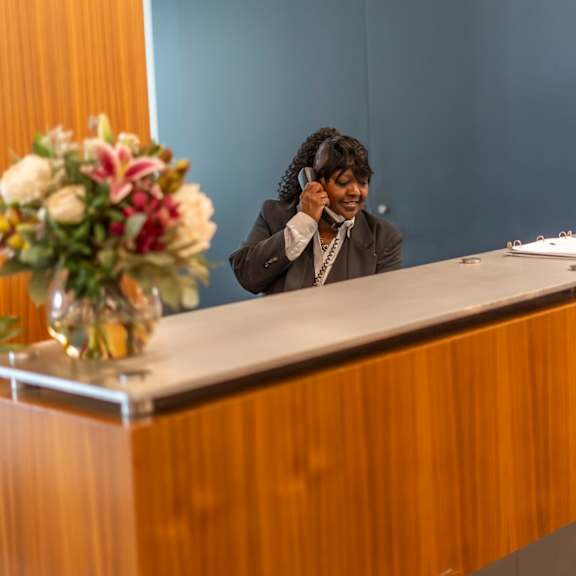 a woman sitting at a desk with a phone to her ear at west77, chicago, 60654
