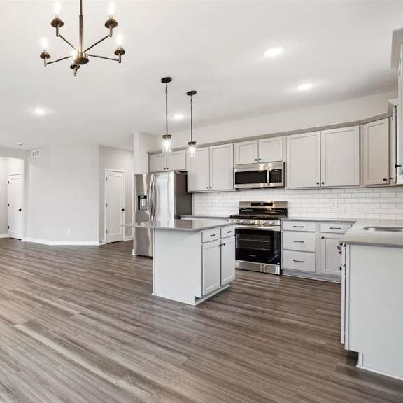 a spacious kitchen and living room with a fireplace.